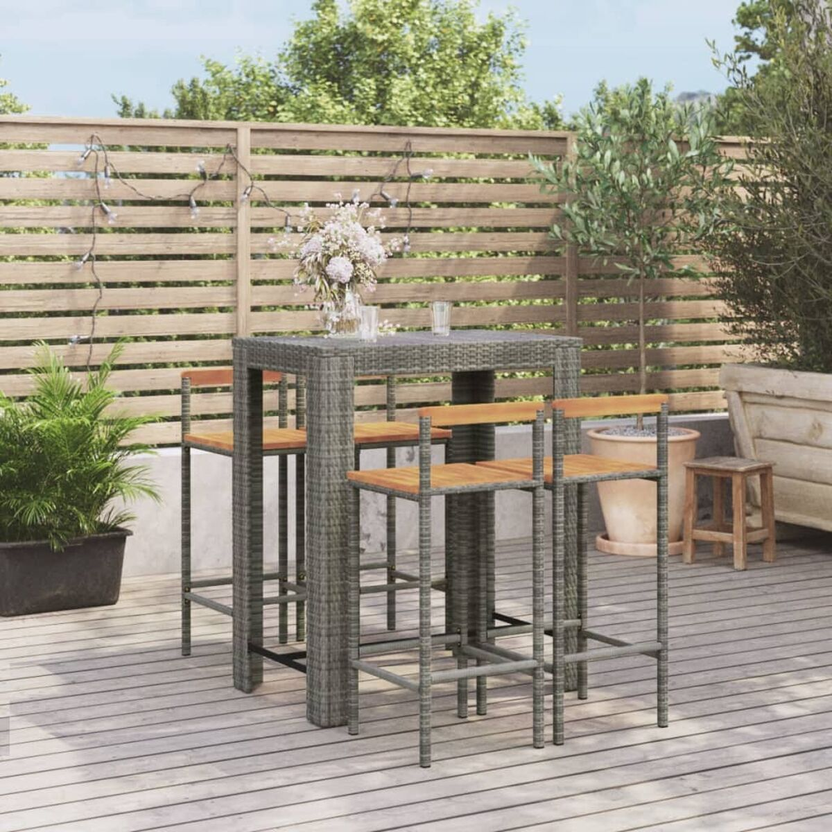 Bar-Set im Freien mit hohen Hockern und Holztisch.