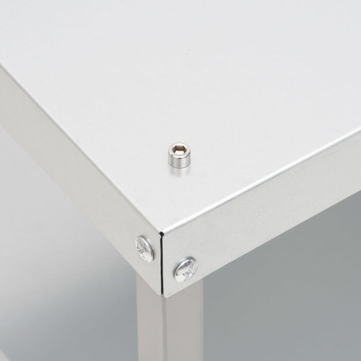 Nahaufnahme einer Metallecke. In der Mitte befindet sich eine Schraube. Das Metall ist silber. Weißer Hintergrund.