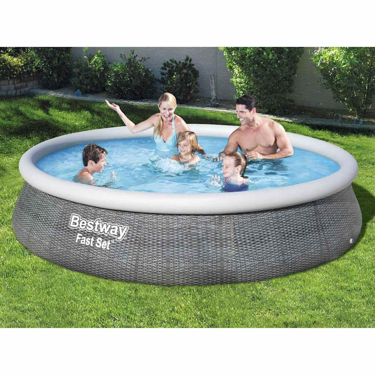 Familie in einem aufblasbaren Pool. Blaues Wasser, graue Seiten im Flechtstil. Grünes Gras.