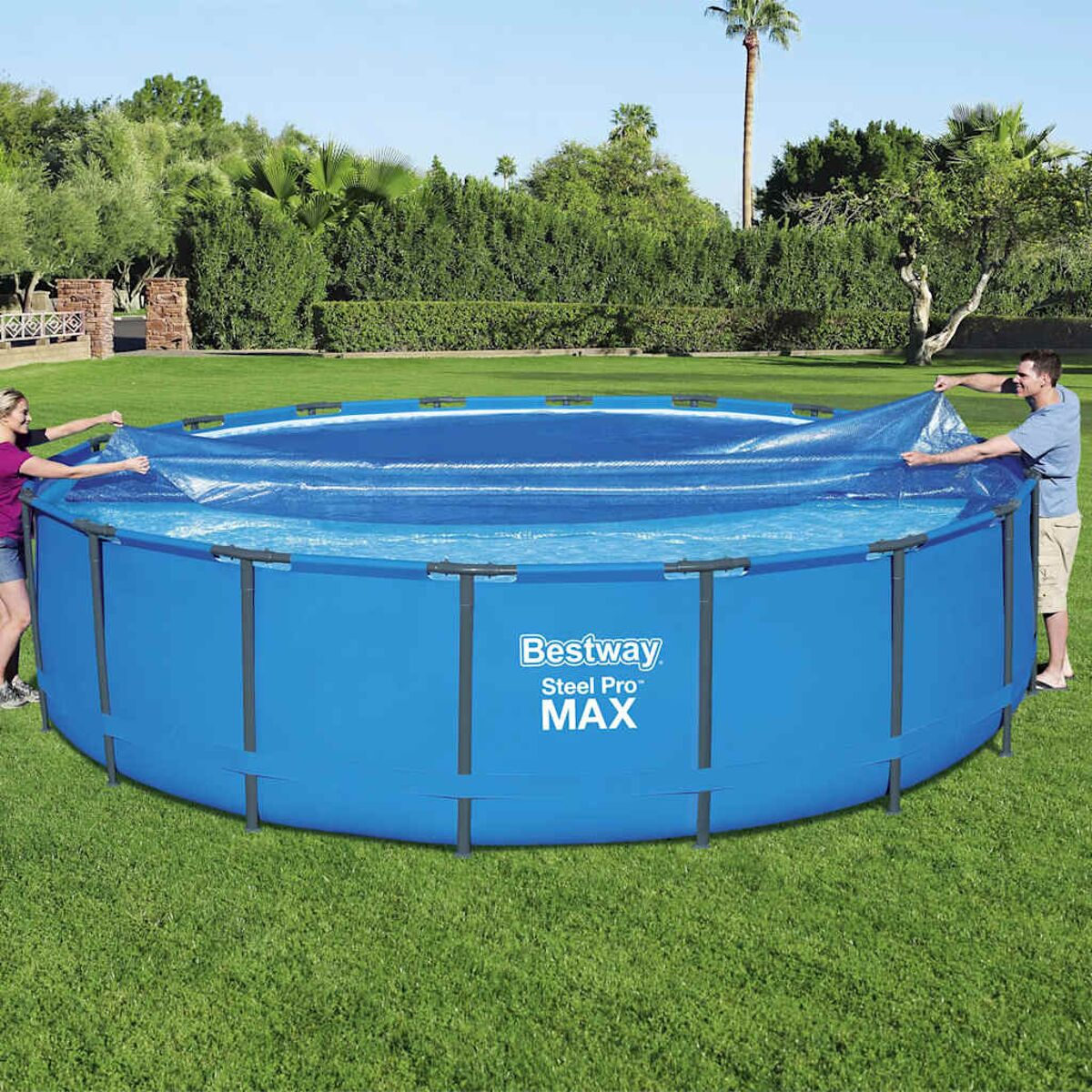 Zwei Personen installieren einen blauen oberirdischen Pool. Grünes Gras und Bäume im Hintergrund.