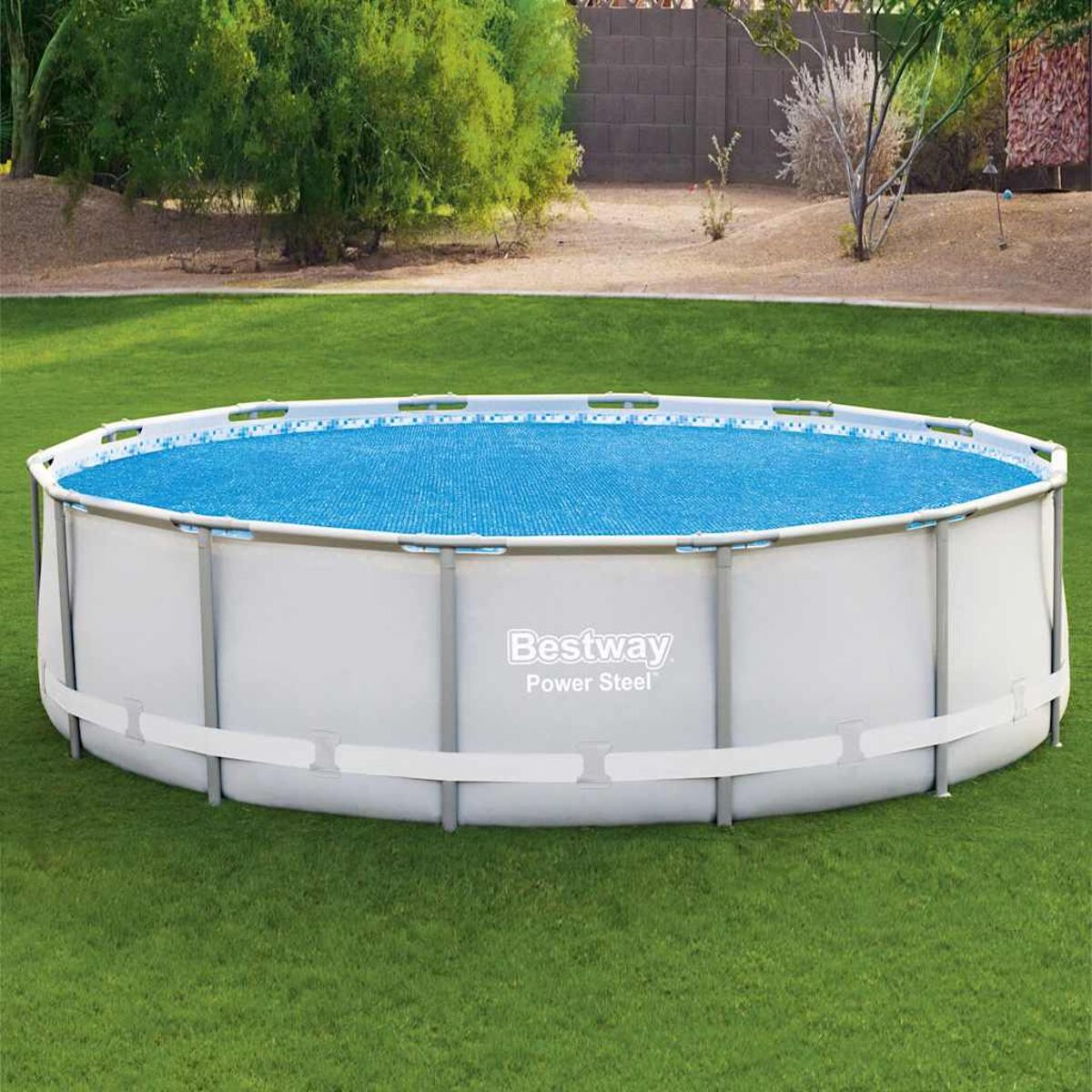 Oberirdischer Pool mit blauer Abdeckung auf grünem Gras, umgeben von einem weißen Rahmen.