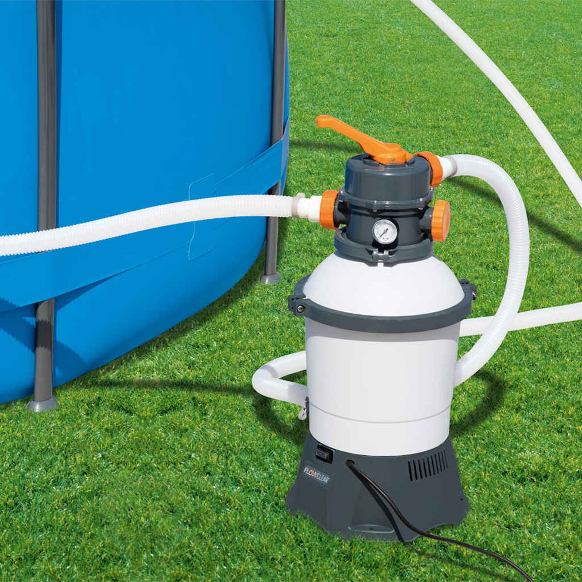 Poolfiltersystem, weiß und grau, mit angeschlossenen Schläuchen. Auf grünem Gras platziert.