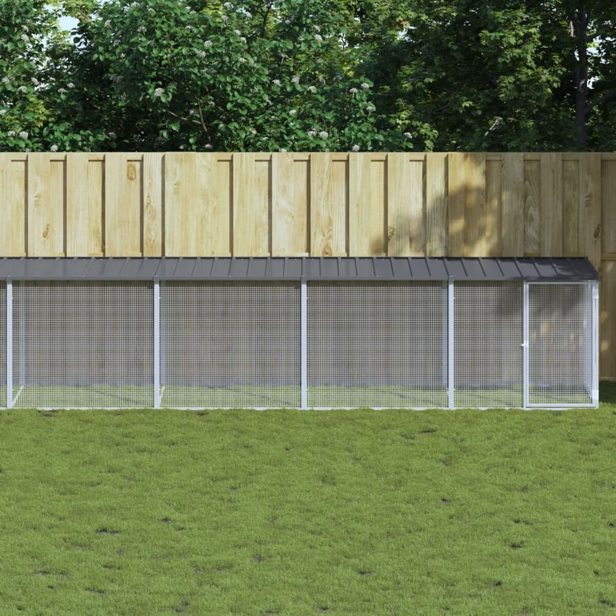 Langer Hühnerstall mit Maschenwänden, Tür und Metalldach, auf Gras gesetzt.