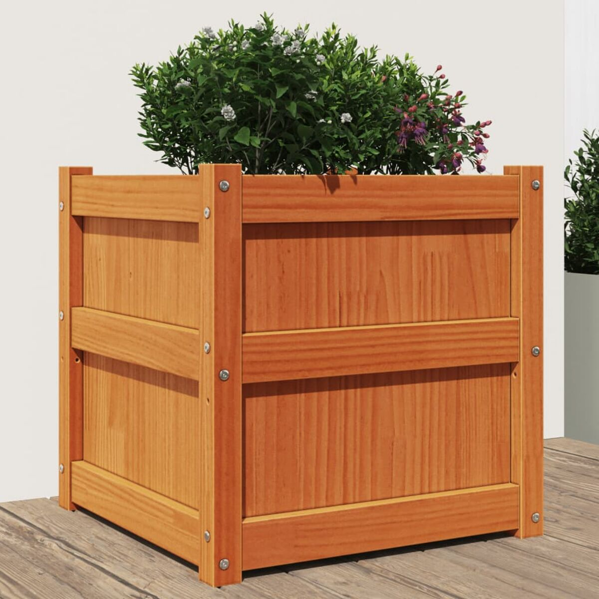 Holzpflanzkasten mit Pflanzen, auf Holzterrasse, mit weißer Wand.
