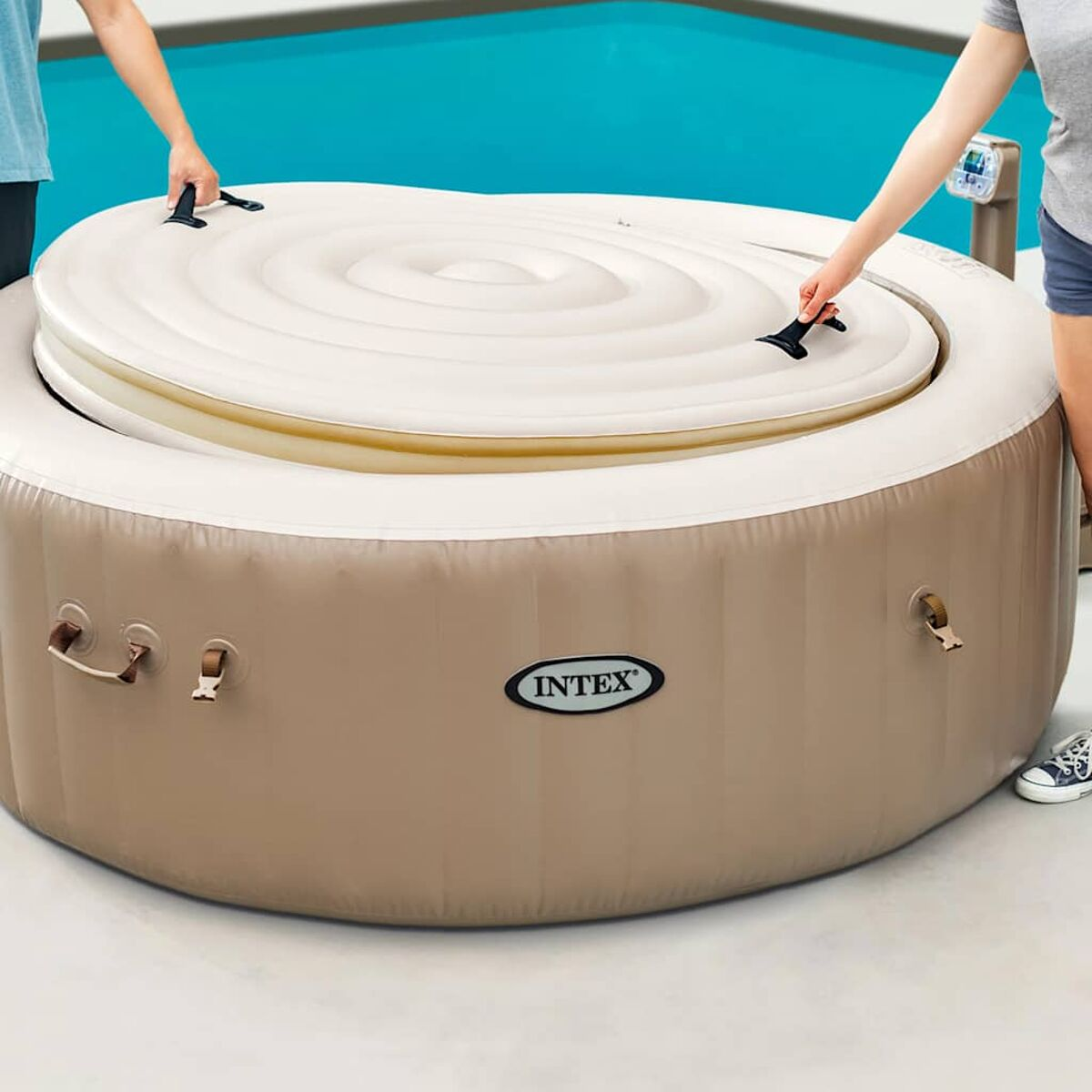 Aufblasbarer Whirlpool, beige, mit Deckel, der von zwei Personen aufgelegt wird.