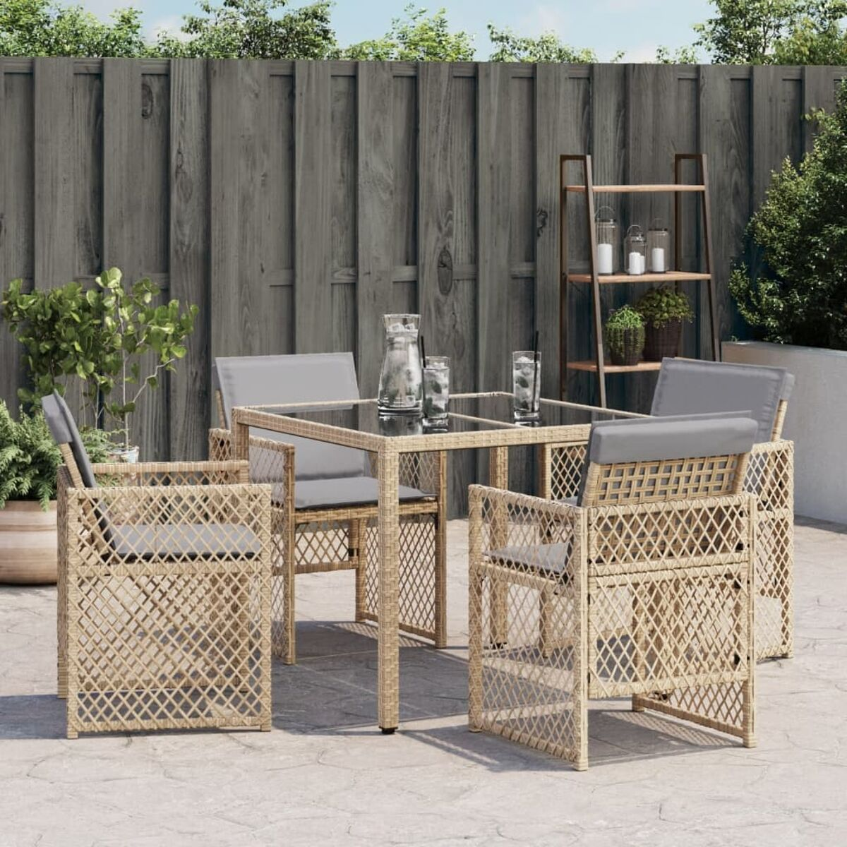 Set da pranzo all'aperto con tavolo in vetro, sedie con cuscini grigi e recinzione in legno.