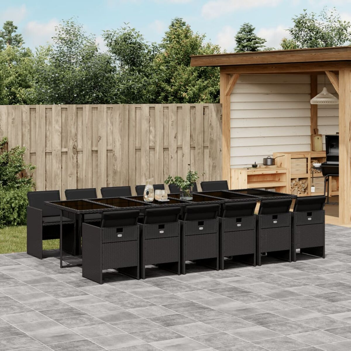 Schwarze Garten-Essgruppe aus Korbgeflecht mit schwarzen Kissen.