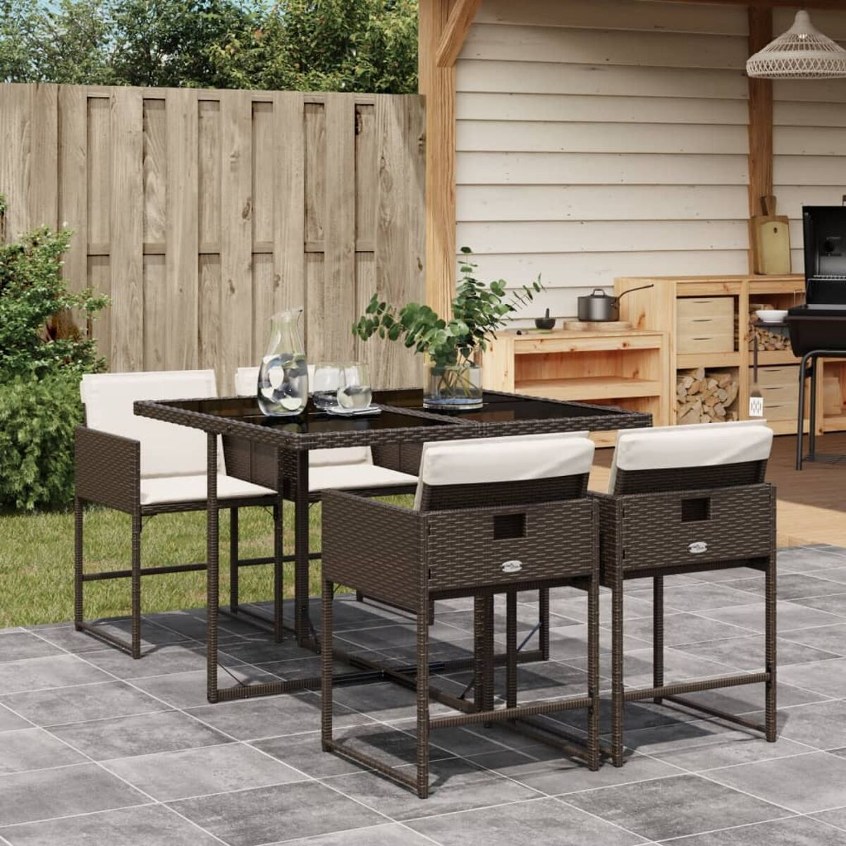 Set da pranzo per esterni con tavolo, sedie e accessori, su un patio piastrellato.