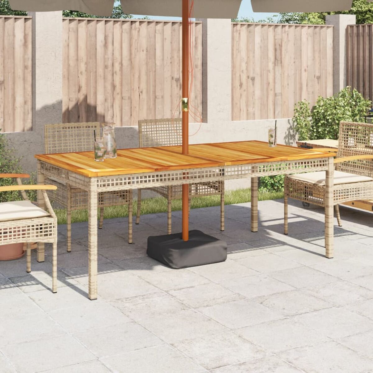 Essgruppe für den Außenbereich mit Holztisch, Sonnenschirm und Rattanstühlen.