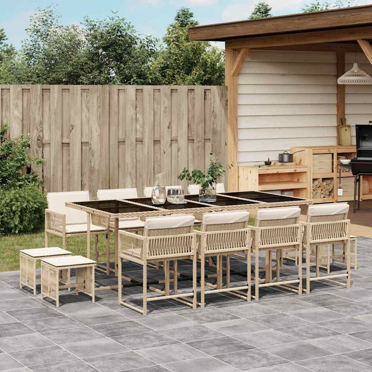 Set da pranzo all'aperto con tavolo e sedie. Pergola in legno e verde sullo sfondo.