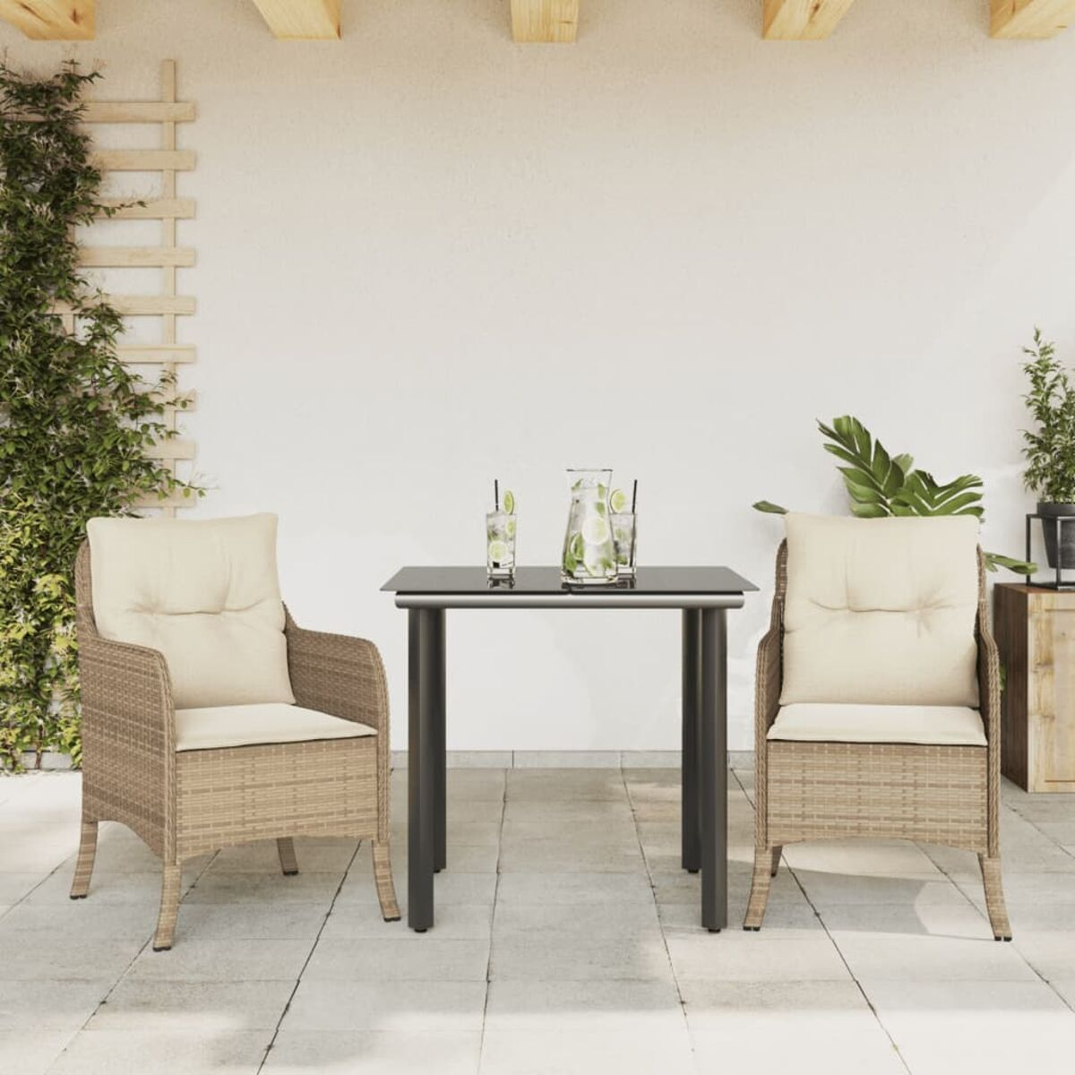 Zwei Rattanstühle und ein Tisch mit Getränken auf einer Terrasse. Weiße Wand.