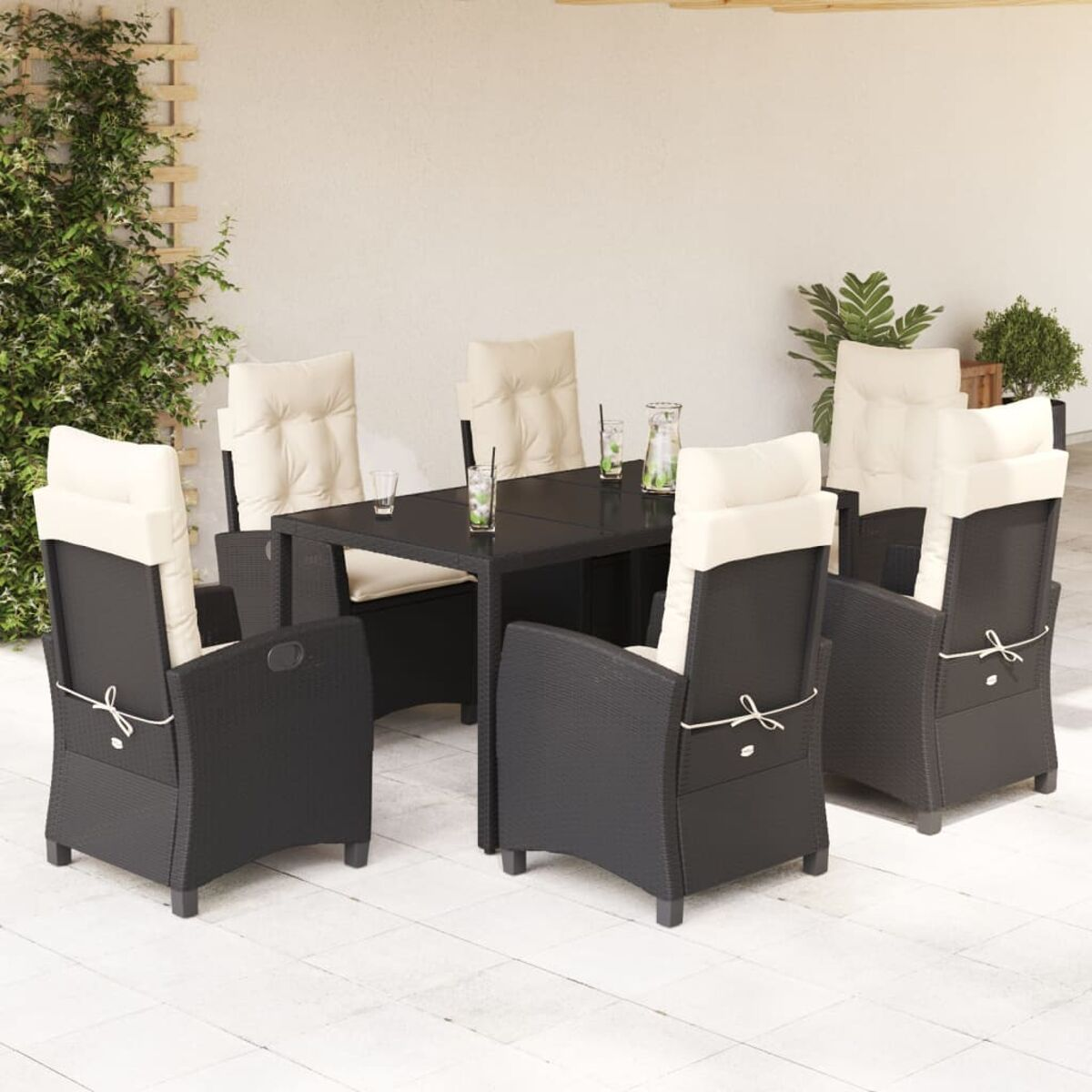 Essgruppe für den Außenbereich. Tisch und Stühle. Schwarzes Rattan mit weißen Kissen.