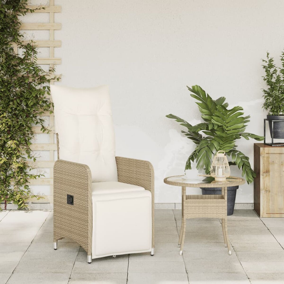 Korbstuhl mit weißem Kissen, kleinem Tisch und Pflanzen auf einer Terrasse mit weißer Wand.