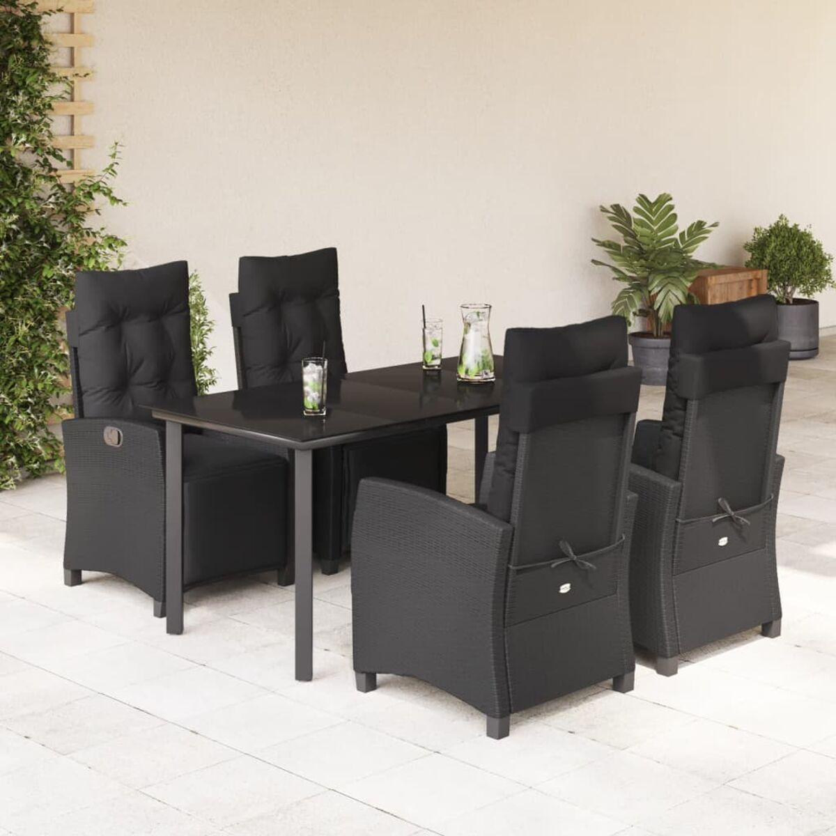 Essgruppe im Freien mit schwarzen Stühlen und einem Tisch mit schwarzen Kissen. Sonniger Tag.
