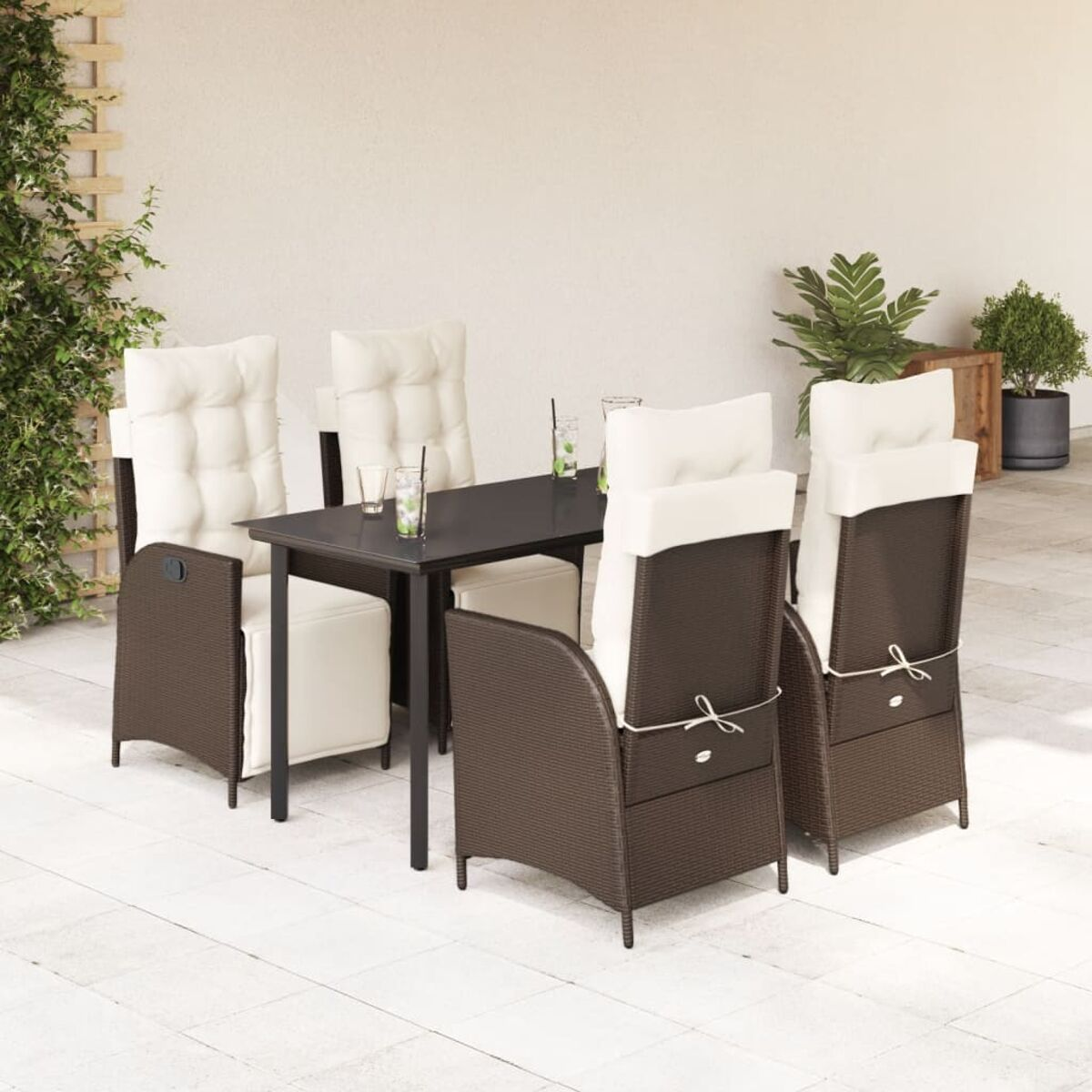 Set da pranzo per esterni con sedie marroni, cuscini color crema e tavolo nero su un patio.