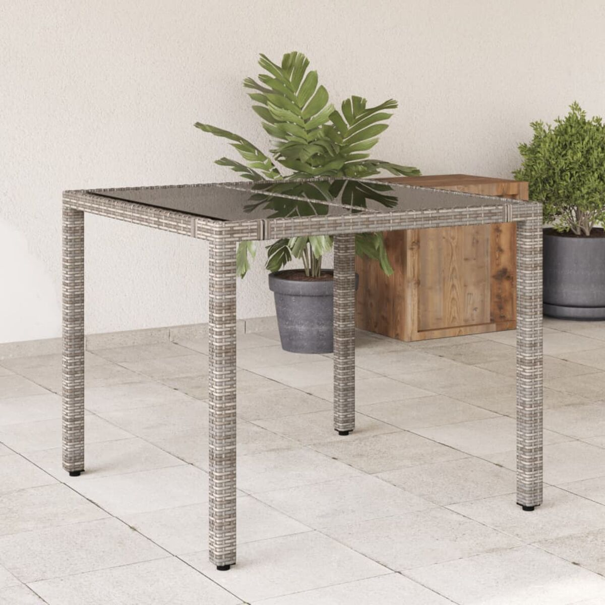 Quadratischer Outdoor-Tisch mit einer Topfpflanze. Weißer Hintergrund.