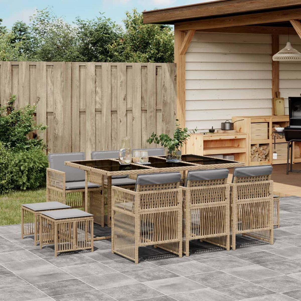 Set da pranzo su patio con sedie in rattan, tavolo in vetro e pergola.