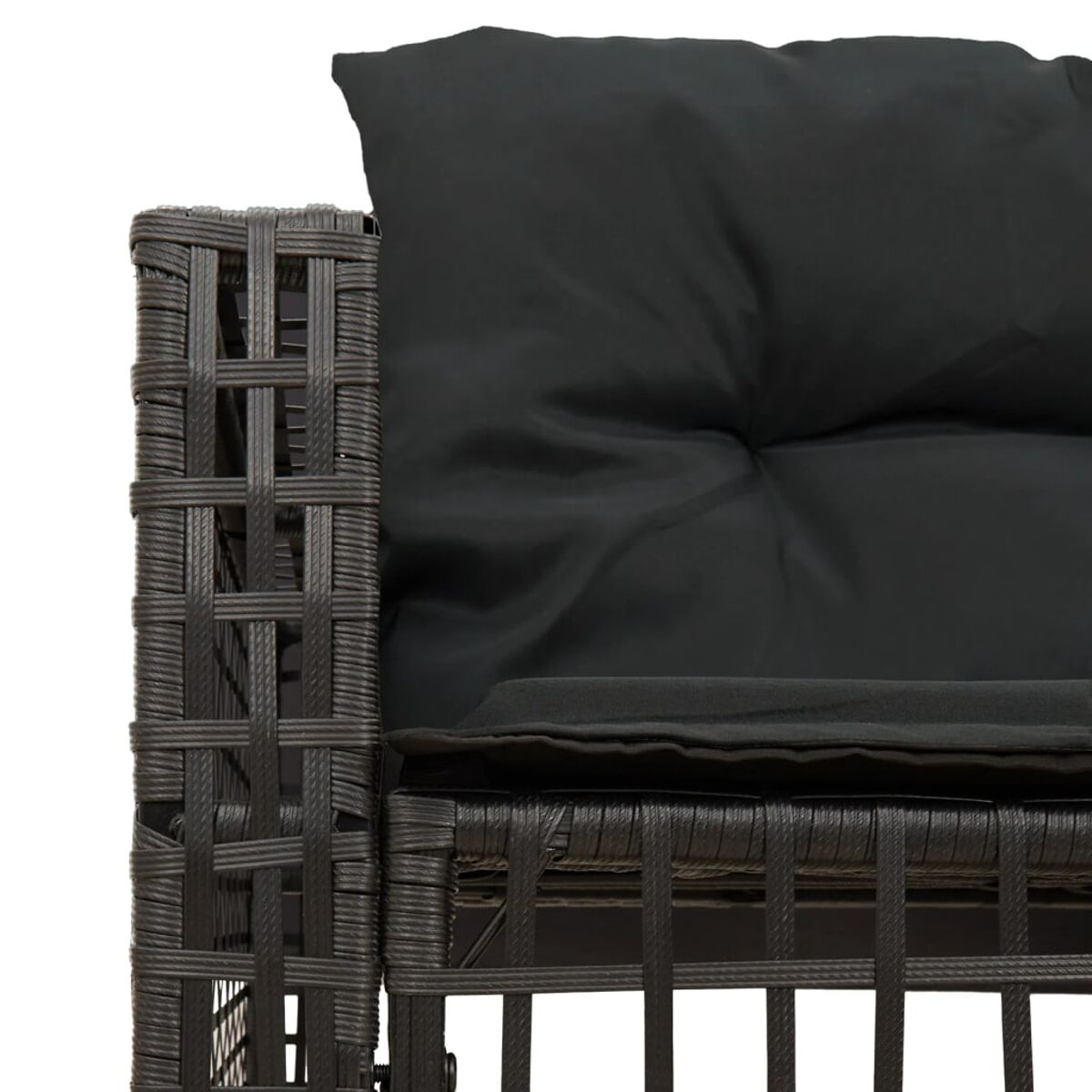Primo piano di un bracciolo di divano in vimini nero con cuscino.