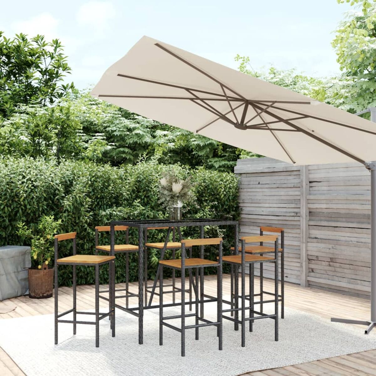 Essgarnitur im Freien mit Tisch, Stühlen und großem Sonnenschirm in einem Garten.