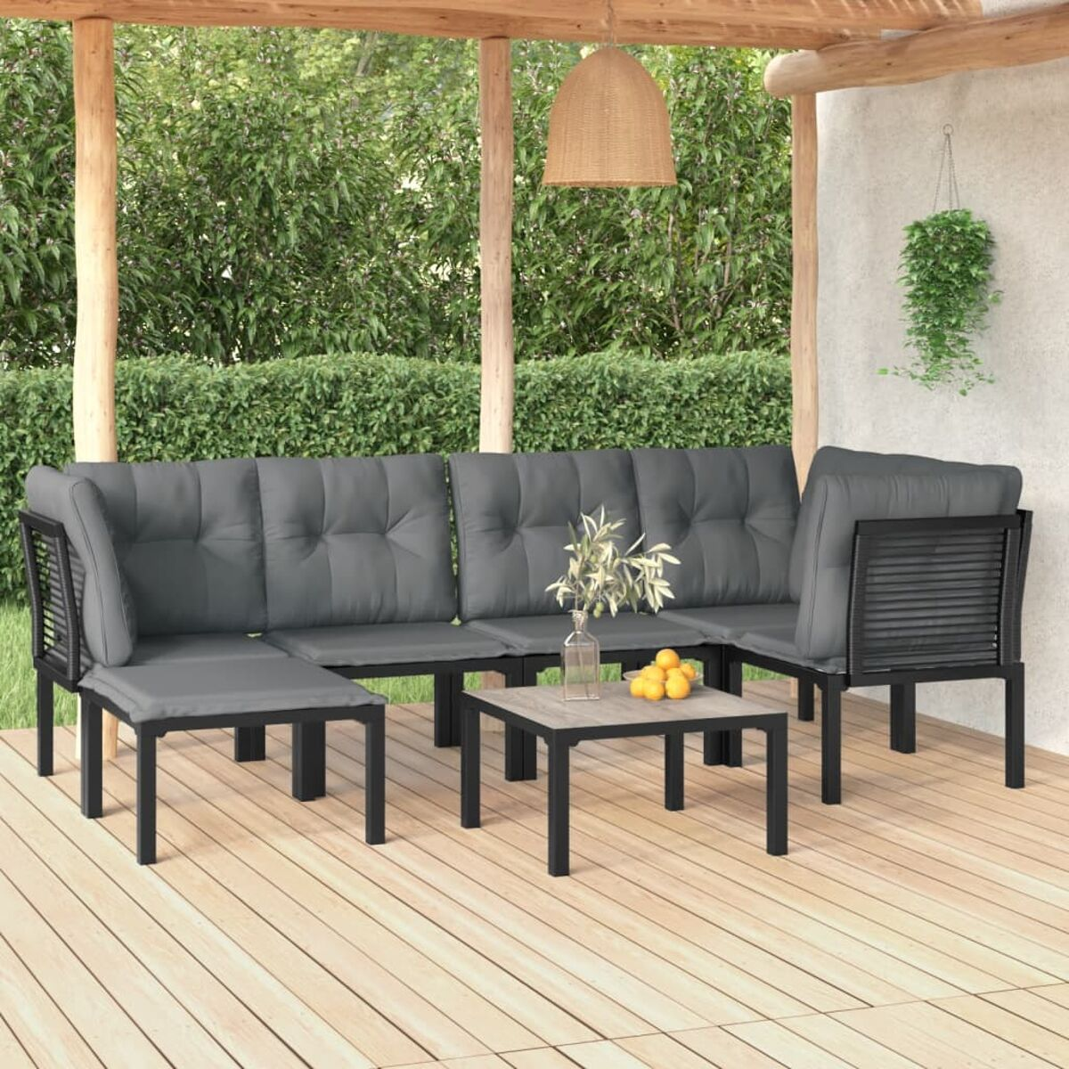 Outdoor-Ecksofa mit Couchtisch. Es hat graue Kissen.