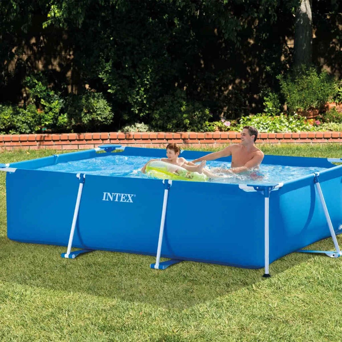 Ein Mann und ein Kind spielen in einem blauen rechteckigen Intex-Pool im Garten.