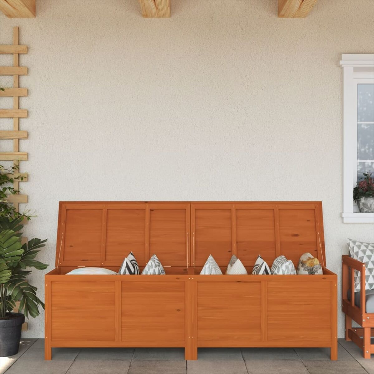Holz-Aufbewahrungstruhe mit offenem Deckel. Beige Kissen im Inneren. Weißer Wandhintergrund.