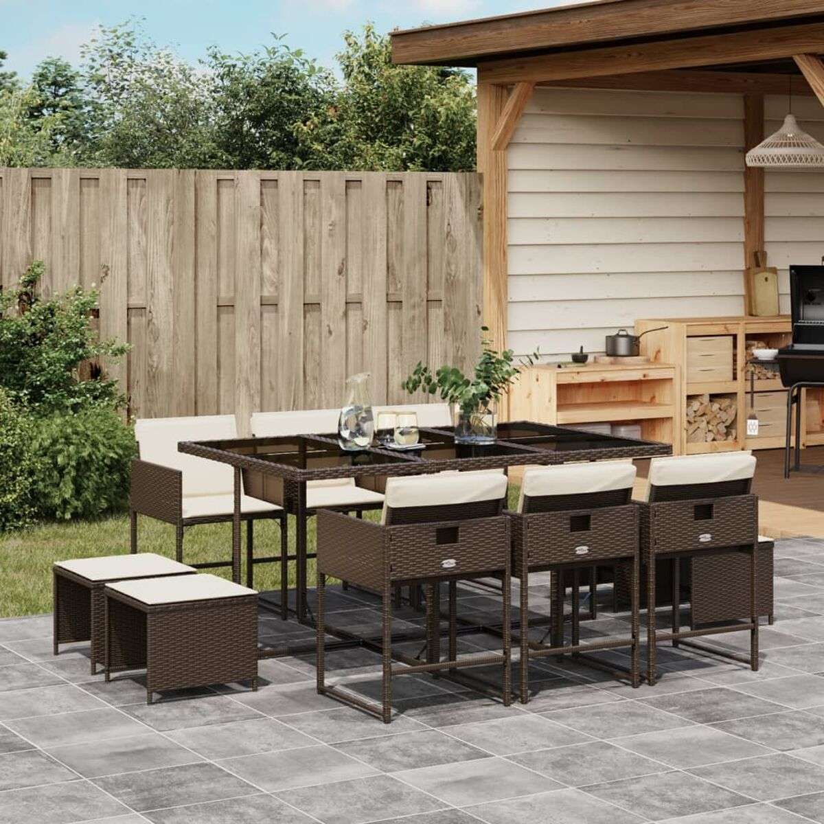 Braunes Rattan-Terrassen-Set mit Tisch, sechs Stühlen und zwei Fußstützen. Außenbereich mit Holzhintergrund.