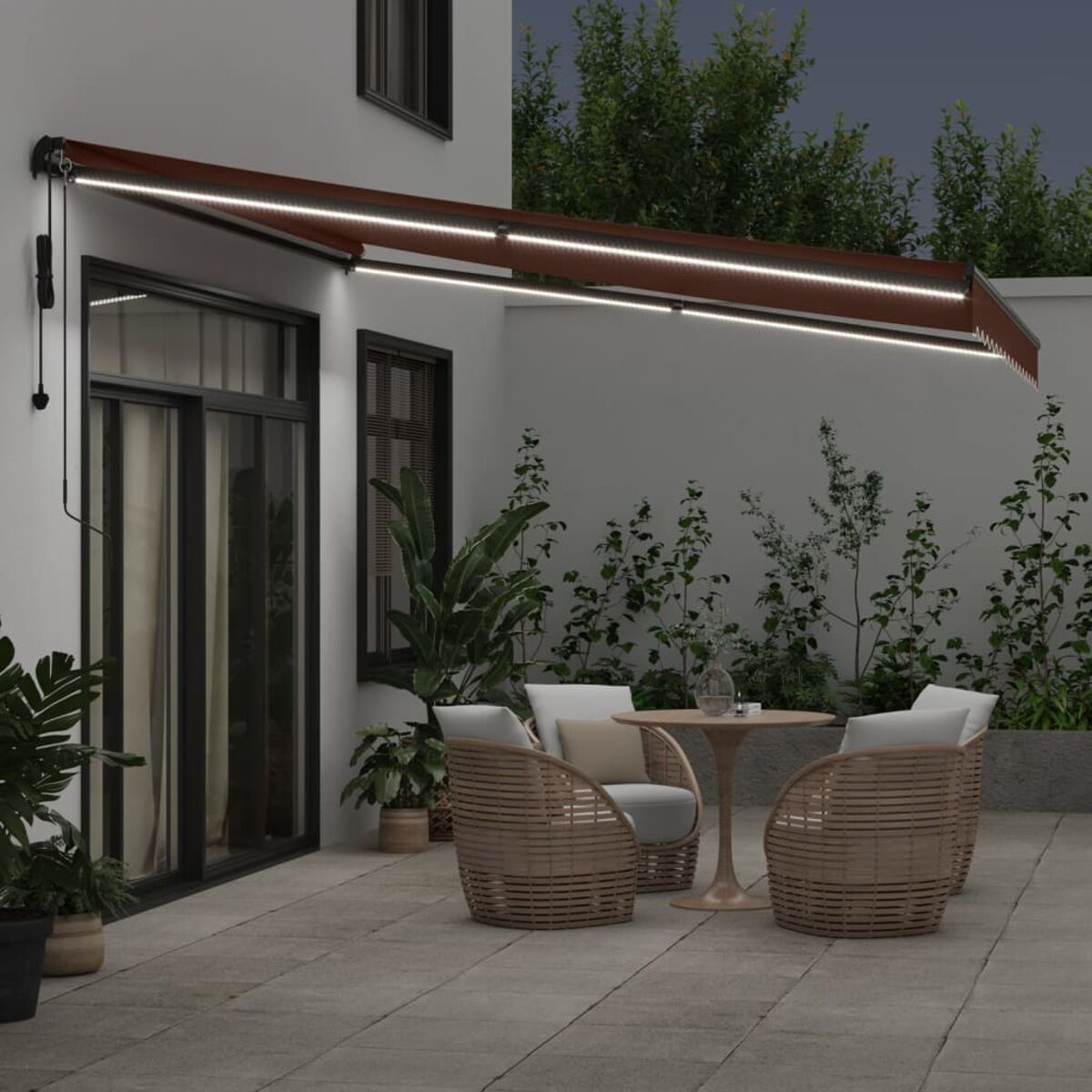 Eine nächtliche Terrasse mit Lichtern, Markise, Möbeln und Pflanzen.
