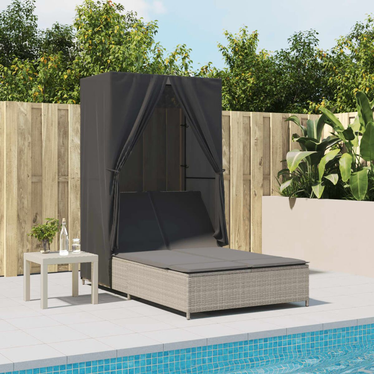 Lettino prendisole da esterno con baldacchino nero. È accanto a una piscina e a un tavolino con bevanda.