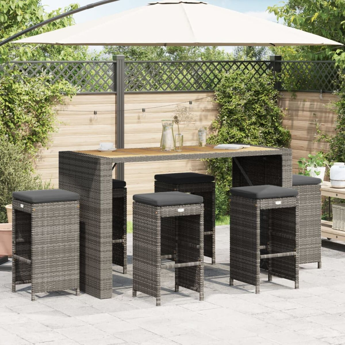 Set bar da esterno con tavolo alto, sgabelli e ombrellone. Presenta un design in vimini grigio.