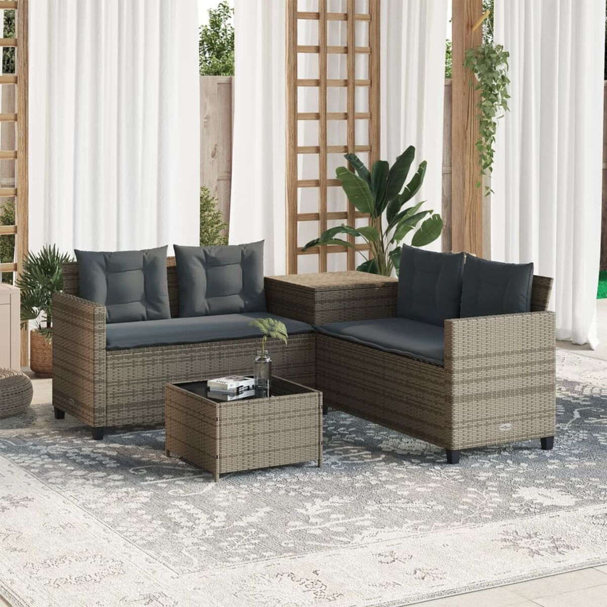 Set divani per esterni. Arredamento in rattan con cuscini grigi. Tavolino tra i divani.
