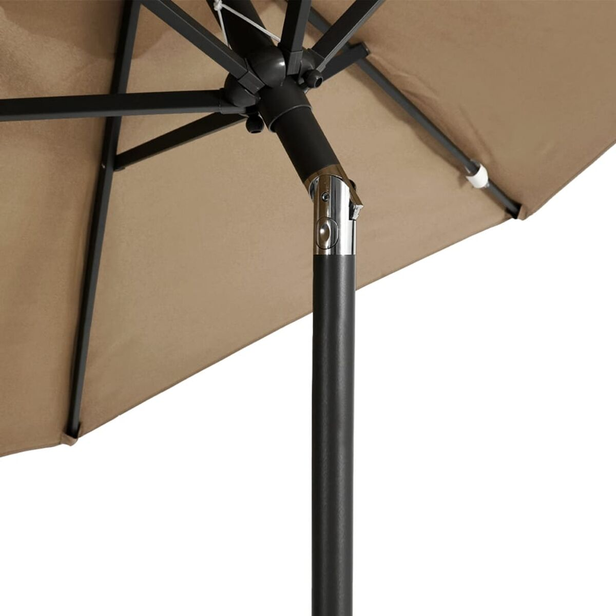 Nahaufnahme eines beigen Sonnenschirms mit schwarzem Mast und Tragwerk.