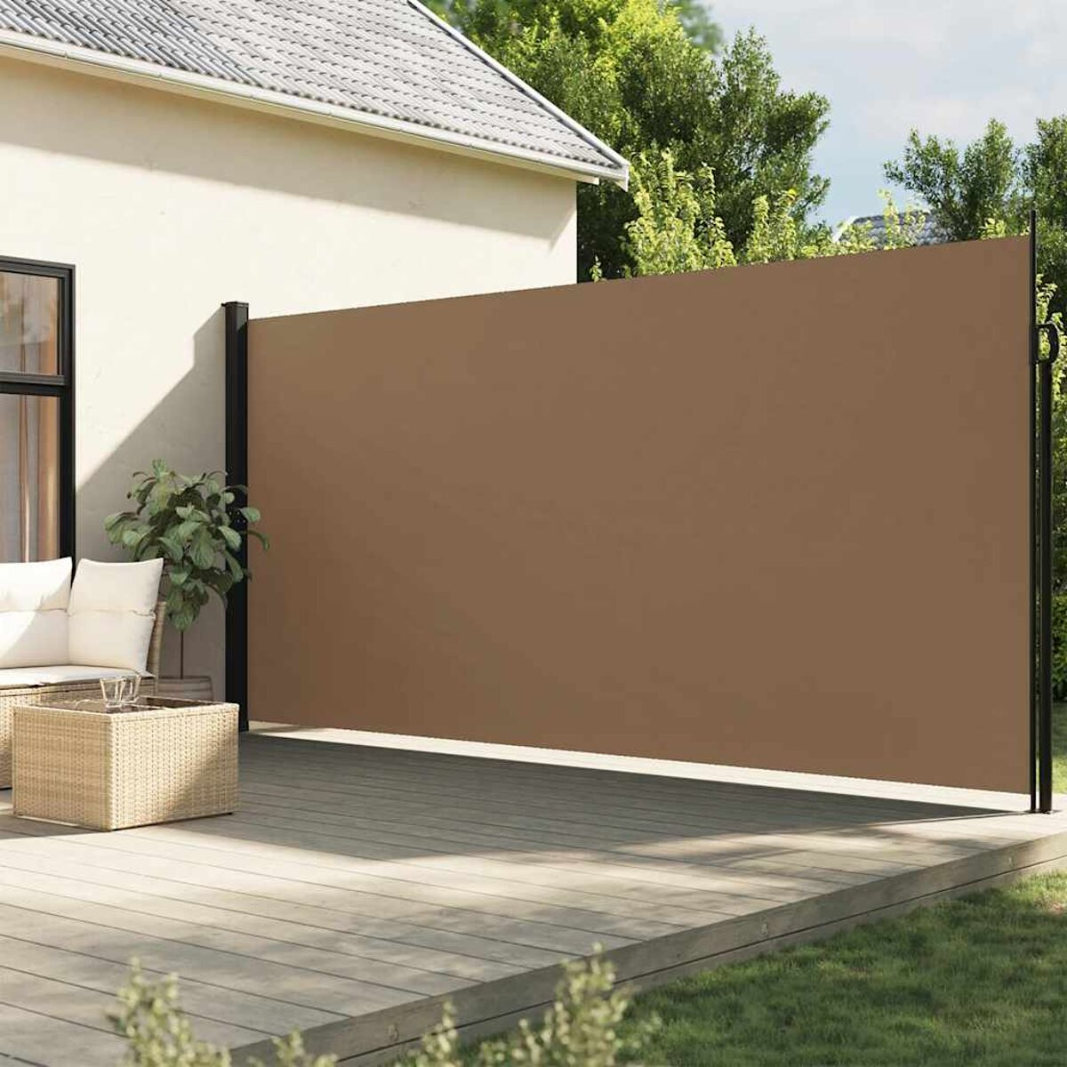 Uno schermo retrattile marrone per esterni installato su un terrazzo di legno accanto a una casa. Lo schermo è esteso.