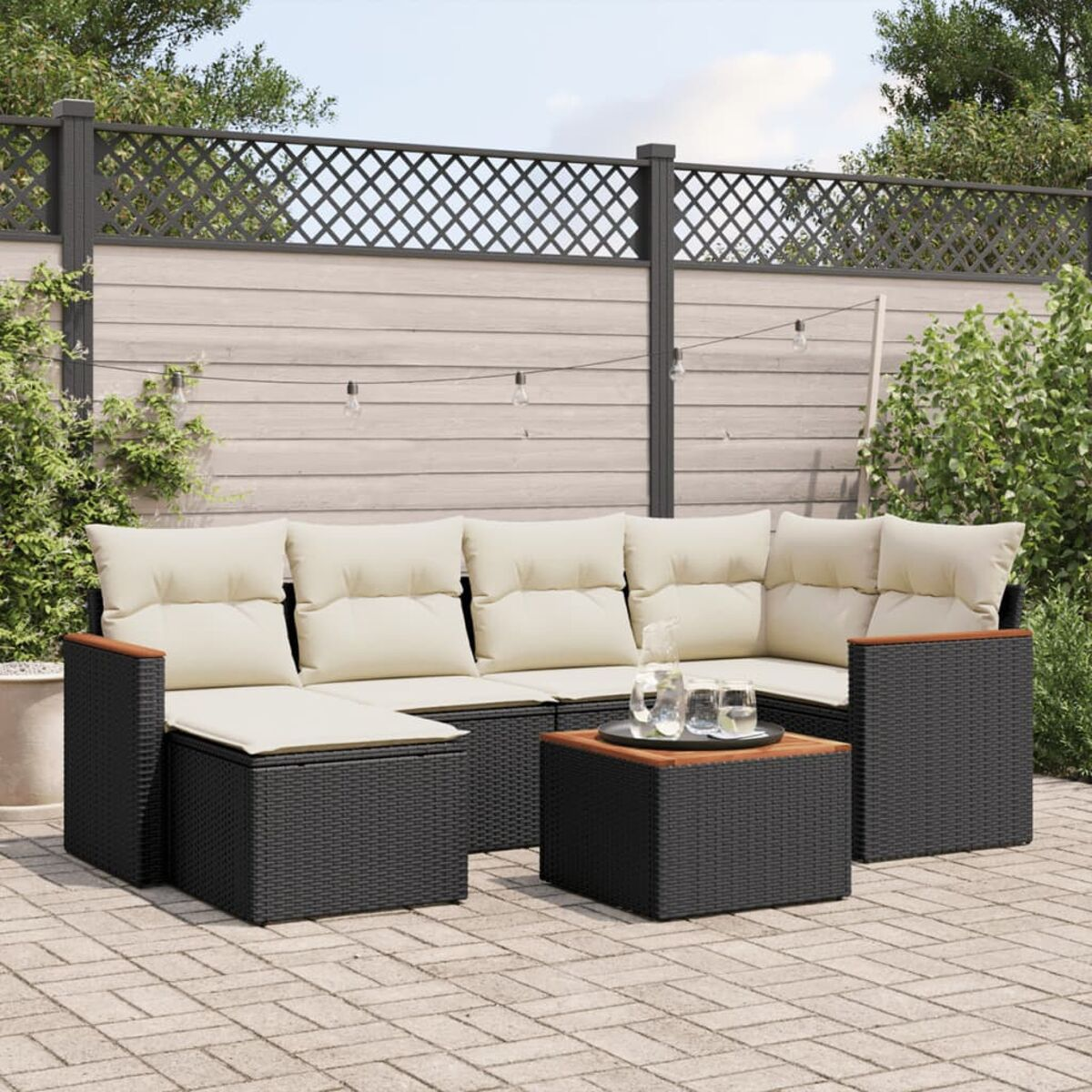 Outdoor-Sofa-Set aus schwarzem Rattan mit Kissen.
