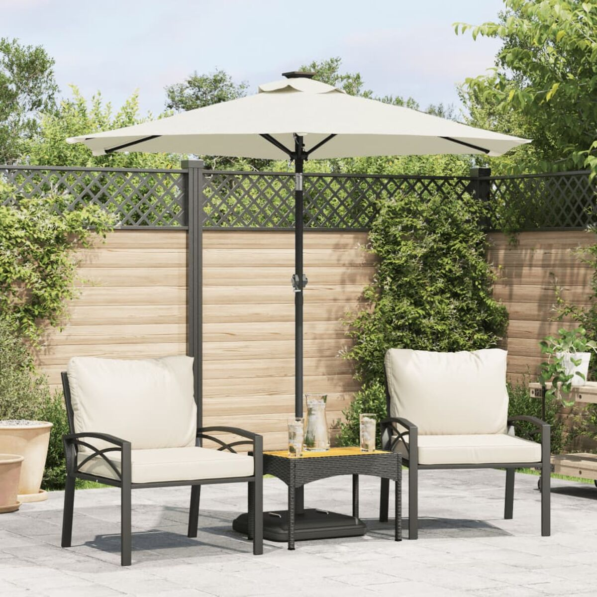 Terrassenset im Freien mit Schirm, Stühlen und Tisch. Grüner Hintergrund.