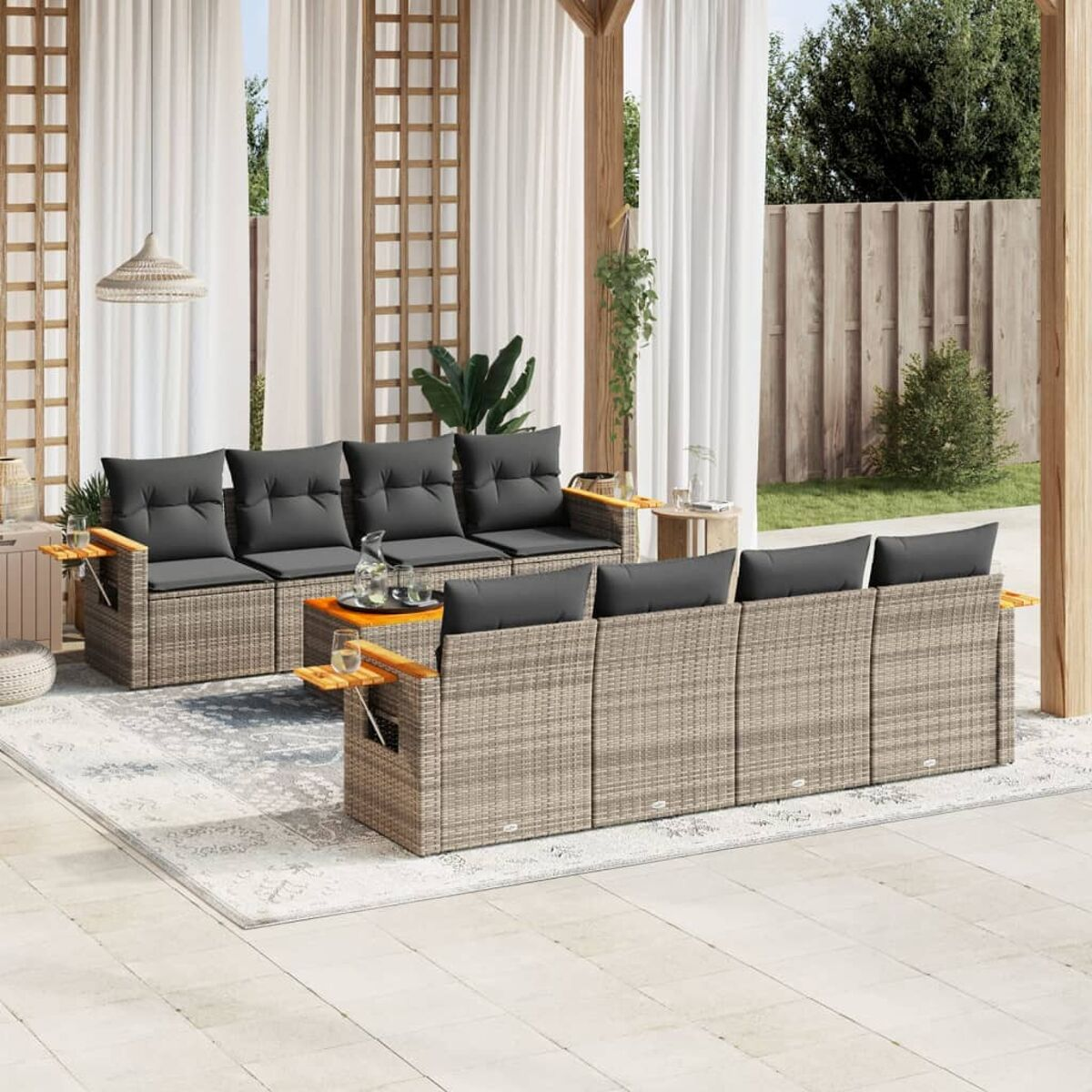 Outdoor-Rattan-Sofagarnitur mit grauen Kissen und kleinen Tischen.