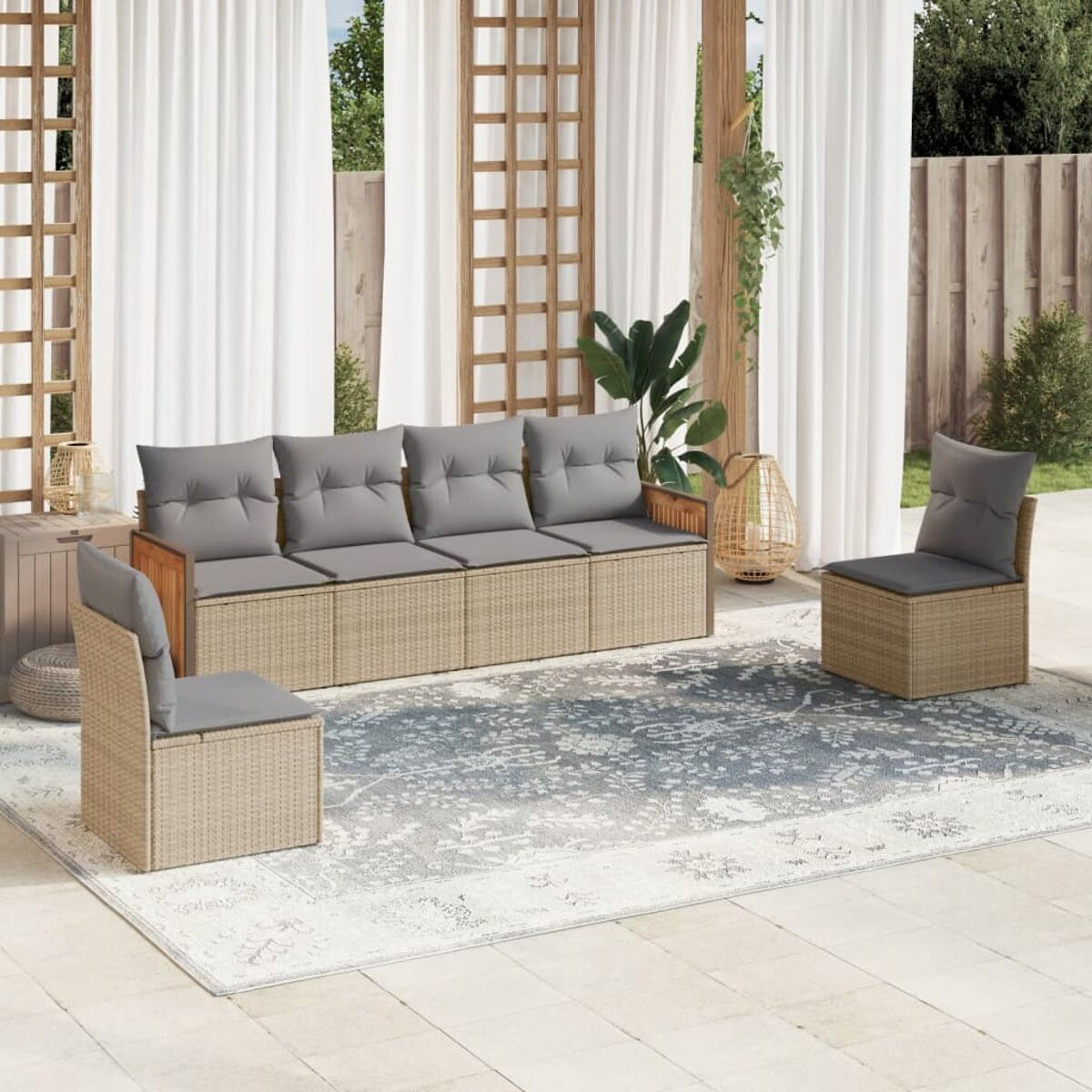 Rattan-Terrassenset mit Sofa und Stühlen, graue Kissen, auf gemustertem Teppich.