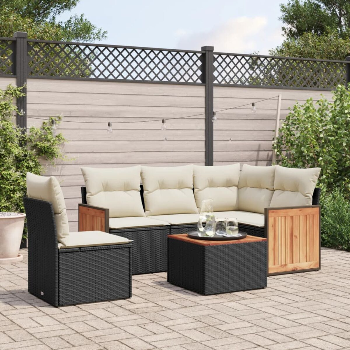 Schwarzes und Holz-Outdoor-Ecksofa mit beigen Kissen. Tisch und Stuhl sind sichtbar. Pflanzen.
