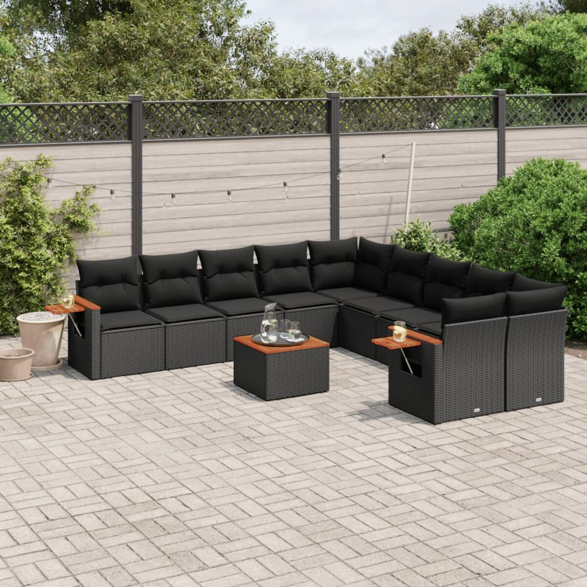 Outdoor-Sitzgruppe mit schwarzen Kissen.