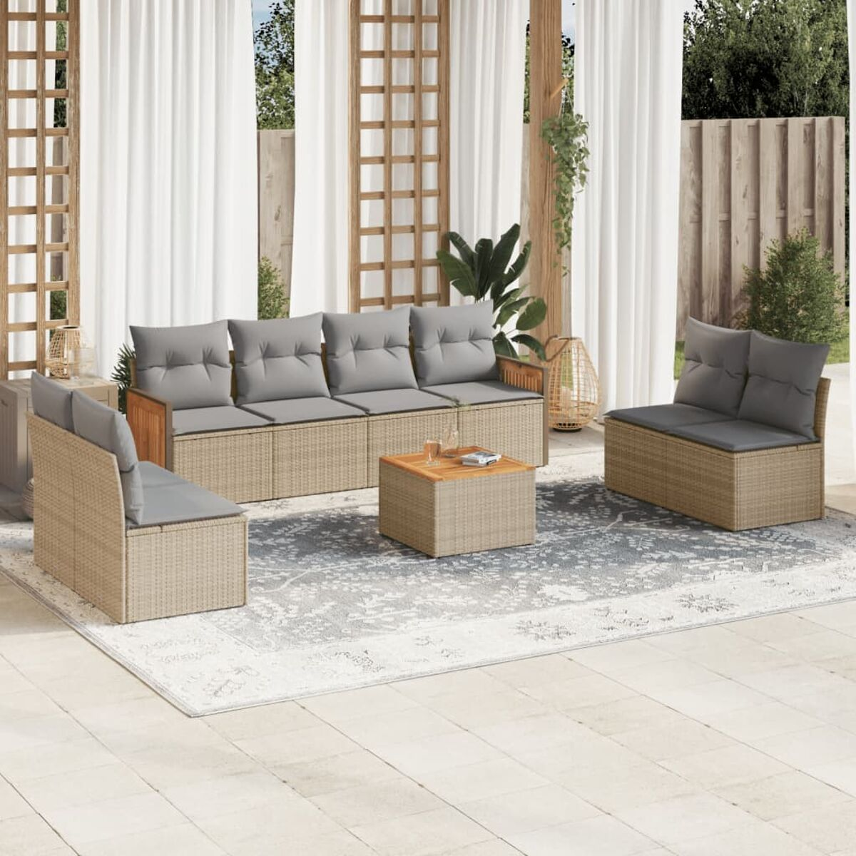 Ein Outdoor-Sofa-Set mit grauen Kissen und Rattanmöbeln.