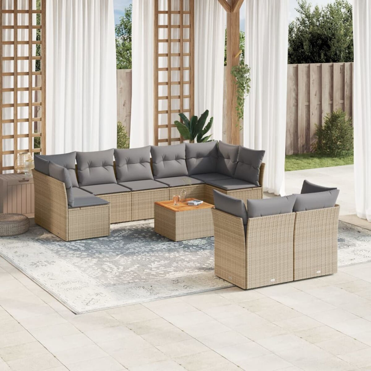Outdoor-Korbmöbelset mit grauen Kissen. Couchtisch, Beistelltische, Teppich und Vorhänge sind sichtbar.