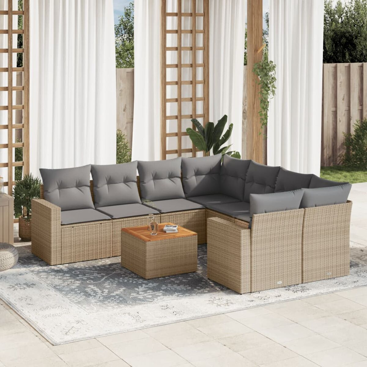 Beiges Outdoor-Ecksofa mit grauen Kissen, quadratischer Holztisch auf grauem Teppich, Garten im Hintergrund.
