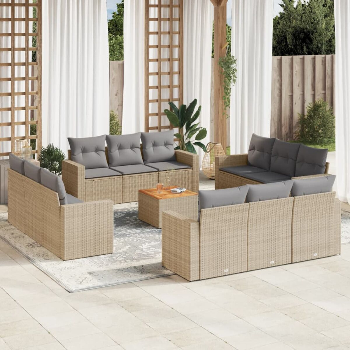 Outdoor-Rattan-Sitzgruppe mit grauen Kissen, einem Couchtisch und einem Teppich auf einer Terrasse mit Vorhängen.