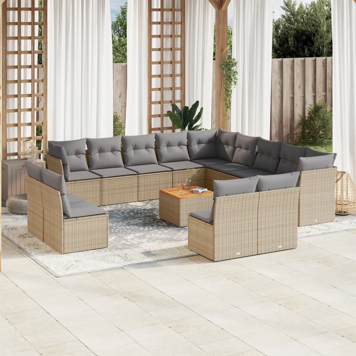 Rattansofa mit grauen Kissen und kleinem Holztisch auf gemustertem Teppich, Outdoor-Setting.