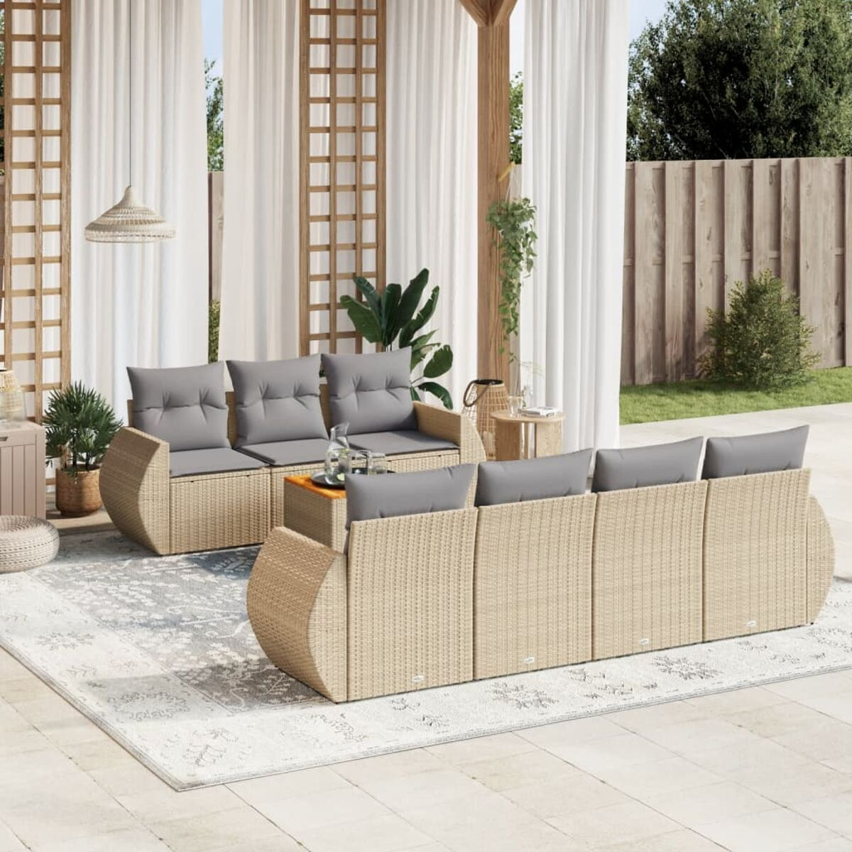 Rattansofa im Freien mit grauen Kissen, Holztisch, auf einem Teppich.