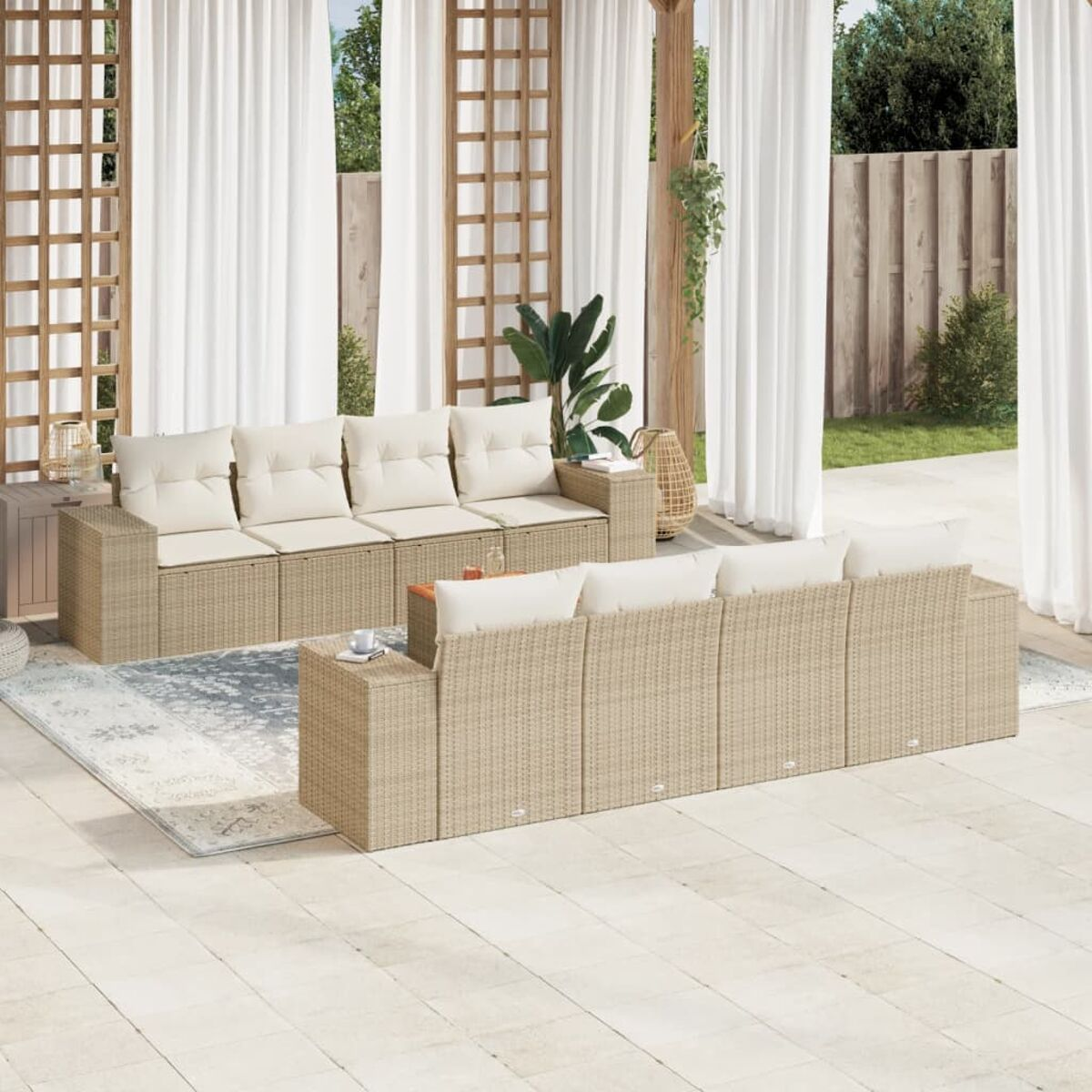 Beiges Korbmöbel-Set mit cremefarbenen Kissen, Couchtisch und Teppich auf der Terrasse.