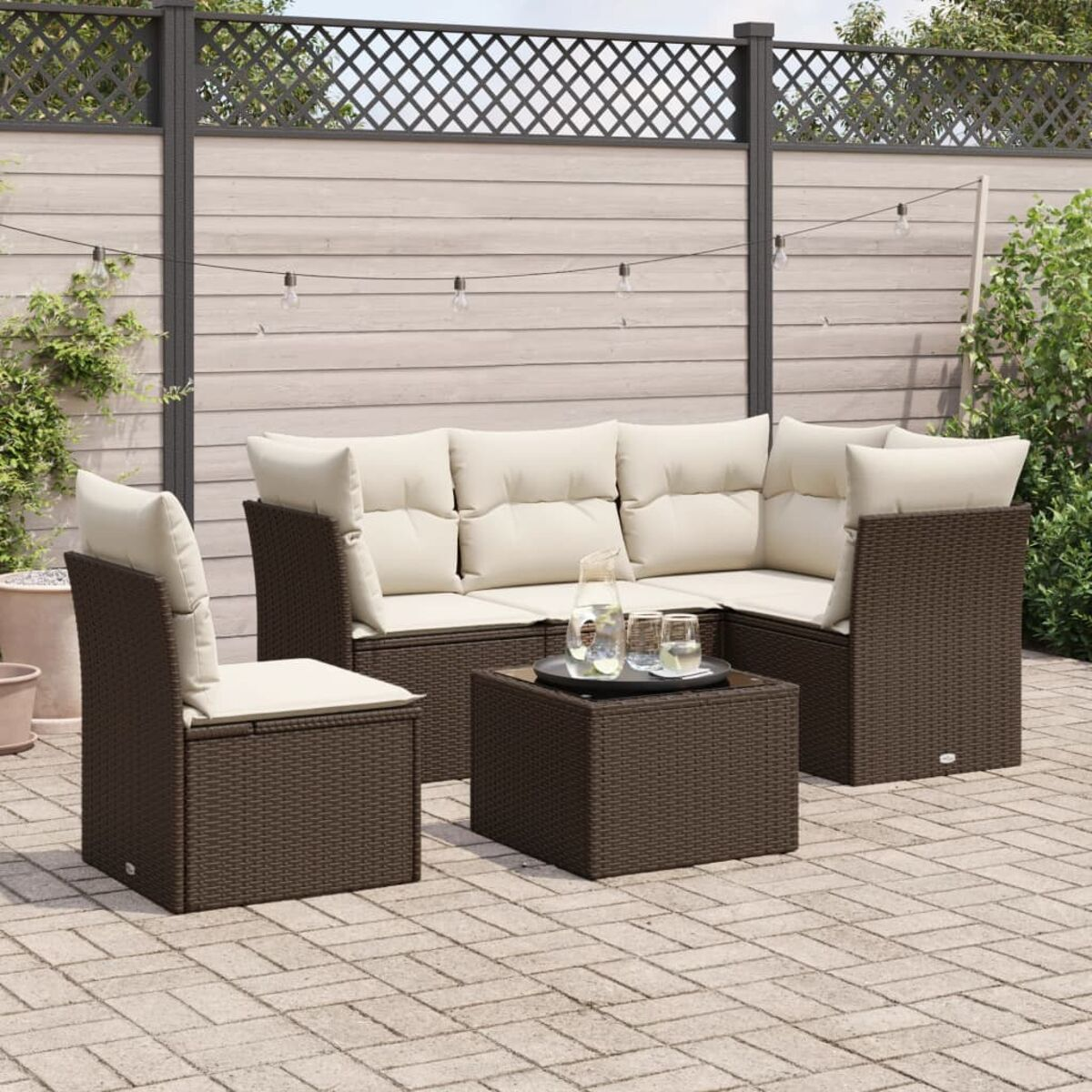 Un set da patio in rattan marrone con un divano angolare, una sedia e un tavolino.