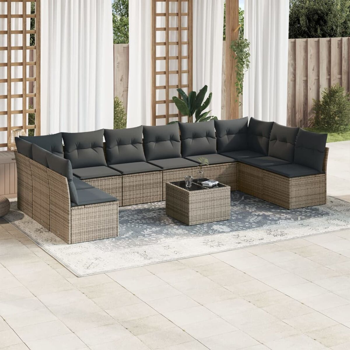 Outdoor-Rattan-Sofa-Set. Graue Kissen, neutraler Rahmen, ein Teppich und ein Couchtisch.