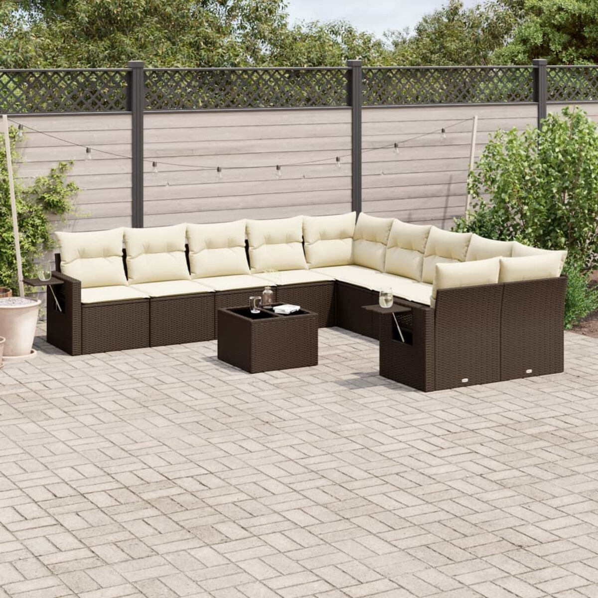 Set divano in vimini marrone con cuscini beige e tavolino.