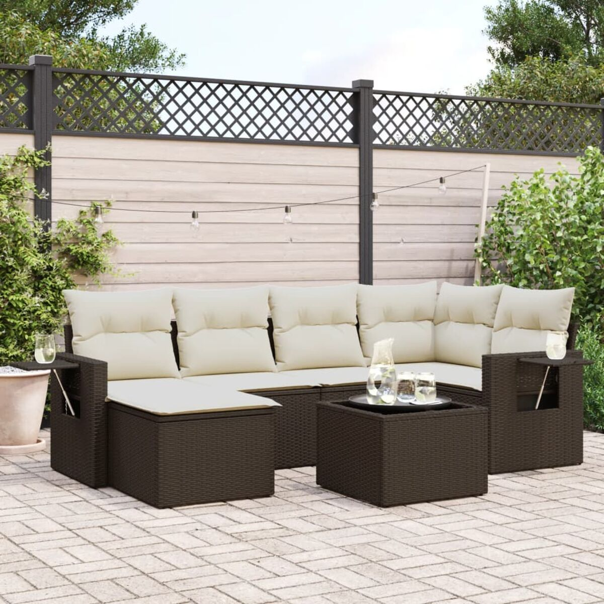 Divano angolare marrone da esterno con cuscini beige e tavolino con bevande, patio in mattoni.